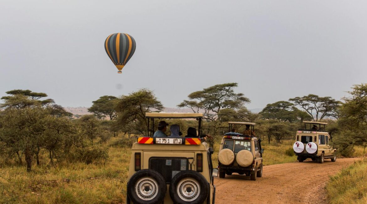 Flying Hot Air Balloon and Off-road Vehicles with Tourists on Safari in Tanzania