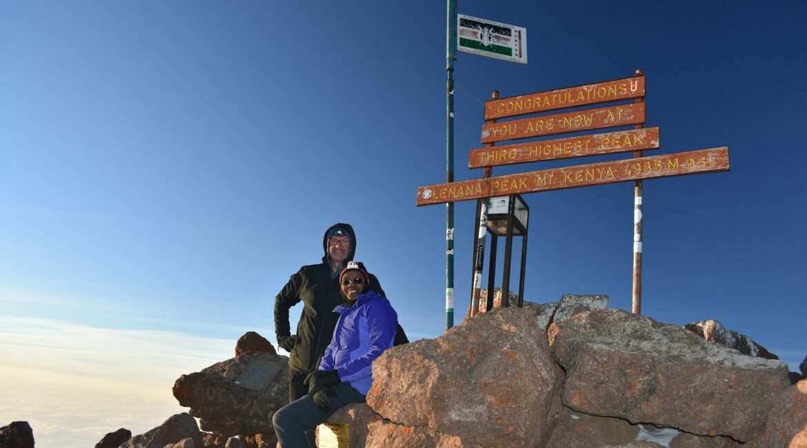 man and woman standing on mountain's peak